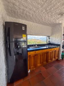 a kitchen with a black refrigerator and a sink at Finca Lituania, El Sisga in Chocontá +26 photos
