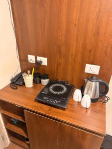 a counter with a tea kettle on top of a cabinet at Hazelnut -Expo India centre in Greater Noida