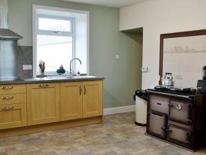 a kitchen with wooden cabinets and a sink and a window at Culquhasen in Gillespie