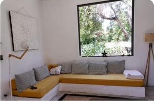 a couch sitting under a window in a room at Filao villa in Riambel