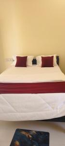 a bed with two red pillows on top of it at Rk comforts & lodge in Madhugiri