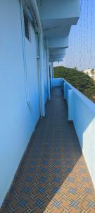 a hallway of a building with blue walls and a sidewalk at Rk comforts & lodge in Madhugiri