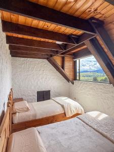 a bedroom with three beds and a large window at Finca Lituania, El Sisga in Chocontá