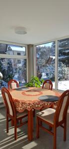 a dining room with a table and chairs and a window at Noclegi pod Brzegiem in Zawoja