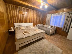 a bedroom with a bed in a wooden room at Chatka na Bečvách in Prostřední Bečva