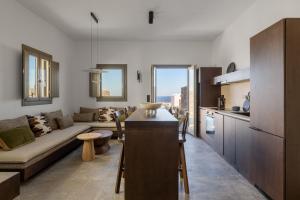 a kitchen and living room with a couch and a table at Koniko Santorini Private Pool Villas in Vóthon