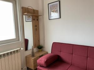 a living room with a red couch and a window at Dolce Vita in Belgrade