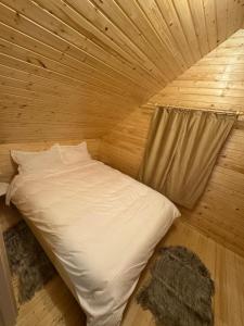a room with a bed in a wooden room at Roua Munților in Dârlești