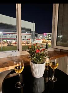 a table with two glasses of wine and a plant at PARK INN in Lukavica