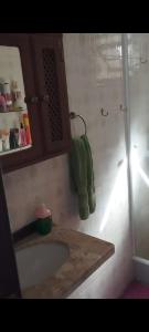 a bathroom with a tub and a shower with a green towel at Suíte da Lagoa in Araruama +3 photos