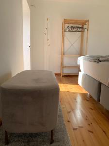 a room with a bed and a ottoman in it at Casa Picobello in Calheta de Nesquim