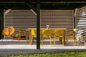 a yellow table and chairs on a patio at Cool Mountain Escape - AC - Summer Cinema - 2BR Family Apartment - Garden - Liptov in Liptovská Kokava