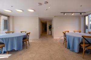 a room with two tables and chairs and a hallway at Jeroom Hostel in Jerusalem