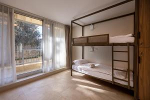 a bedroom with two bunk beds and a window at Jeroom Hostel in Jerusalem
