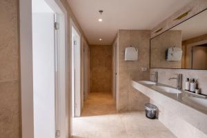 a bathroom with two sinks and a walk in shower at Jeroom Hostel in Jerusalem +30 photos