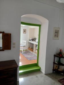 a hallway with a green doorway into a room with a table at Aegaia Residencies in Katapola