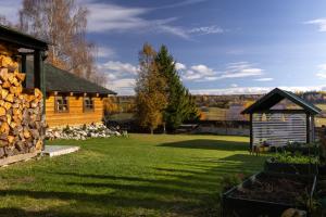 a log cabin and a shed in a yard at Cool Mountain Escape - AC - Summer Cinema - 2BR Family Apartment - Garden - Liptov in Liptovská Kokava