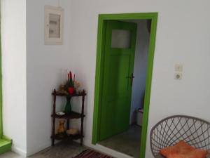 a green door in a room with a mirror at Aegaia Residencies in Katapola