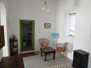 a living room with two chairs and a green door at Aegaia Residencies in Katapola