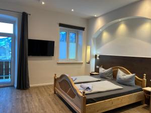 a bedroom with two beds and a flat screen tv at Gasthof Löwen in Pfronten