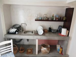 a kitchen with a sink and a counter with baskets at Aegaia Residencies in Katapola