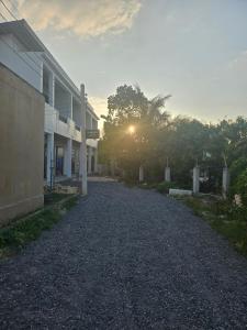 an empty road next to a building with the sun setting at The Hidden Place Bangtao in Bang Tao Beach
