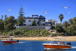 two boats in the water in front of a beach at Villa Sur La Plage in Oualidia