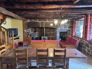 a living room with a table and chairs and a couch at Le relais de Lustrande in Brezons