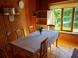 a dining room with a table and chairs and a clock at Paide Homestay in Kriilevälja