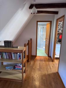 a room with a staircase and a book shelf with books at Le relais de Lustrande in Brezons