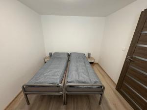 two beds in a small room with a door at Apartman pri kostole in Krásno nad Kysucou