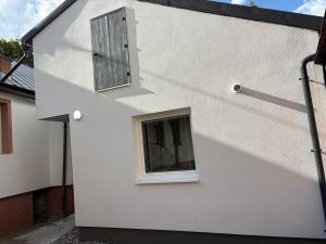 a white building with a window and a door at Apartman pri kostole in Krásno nad Kysucou