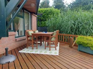 a wooden table and chairs on a deck at Ferienwohnung Nordholland in Nieuwe-Niedorp