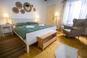 a bedroom with a bed and a chair in a room at DOM na konci in Kostolné