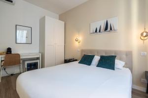 a bedroom with a large white bed and a desk at Chambre 5 La Baieta in Nice