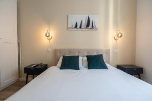 a bedroom with a white bed with two night stands at Chambre 5 La Baieta in Nice