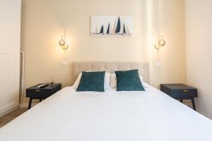 a bedroom with a large white bed with two night stands at Chambre 5 La Baieta in Nice
