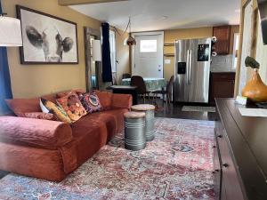 a living room with a brown couch and a kitchen at The Bay House in Shady Side