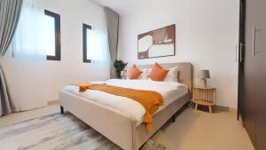 a bedroom with a large white bed with orange pillows at Family Friendly Villa in Abu Dhabi