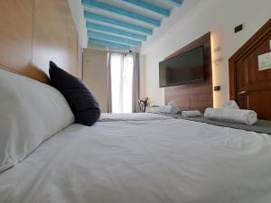 a bedroom with a large white bed with a flat screen tv at TI Central Maria in Maria de la Salut +11 photos