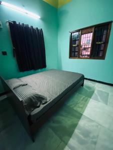 a bedroom with a bed in a room with a window at Butterfly Blossom Villa in Samayapuram