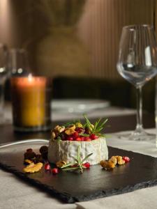 a piece of cheesecake with nuts on a black plate at Tilly's Locanda in Borso del Grappa
