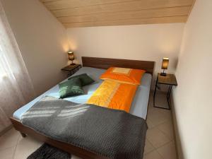two beds in a small room with two lamps at dastraunseehaus in Traunkirchen