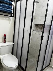 a bathroom with a toilet and a glass shower at Departamento Paty in Tampico +21 photos