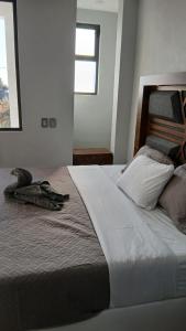 a bedroom with a large bed with two windows at Cuarto en casa de campo in Arandas