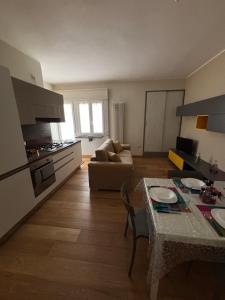 a kitchen and living room with a table and a couch at Fortunato Casa Vacanze in Matera