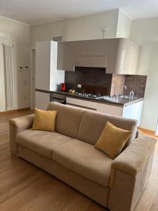 a couch in a living room with a kitchen at Fortunato Casa Vacanze in Matera