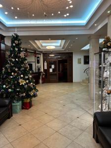 a christmas tree in the middle of a lobby at Hotel Rigga in Władysławowo