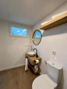 a bathroom with a toilet and a sink and a mirror at Luxury Singular Apartments Padrón in Padrón +31 photos
