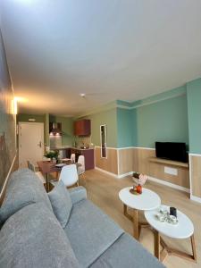 a living room with a blue couch and tables at Luxury Singular Apartments Padrón in Padrón